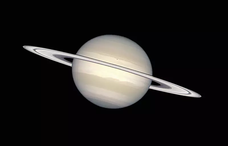 La ringo kirliĝanta ĉirkaŭ Saturno konsistas el pecoj de glacio kaj polvo. Saturno mem estas farita el amoniako glacio kaj metana gaso. La malgranda malhela loko sur Saturno estas la ombro de la luno de Saturno enceladus.