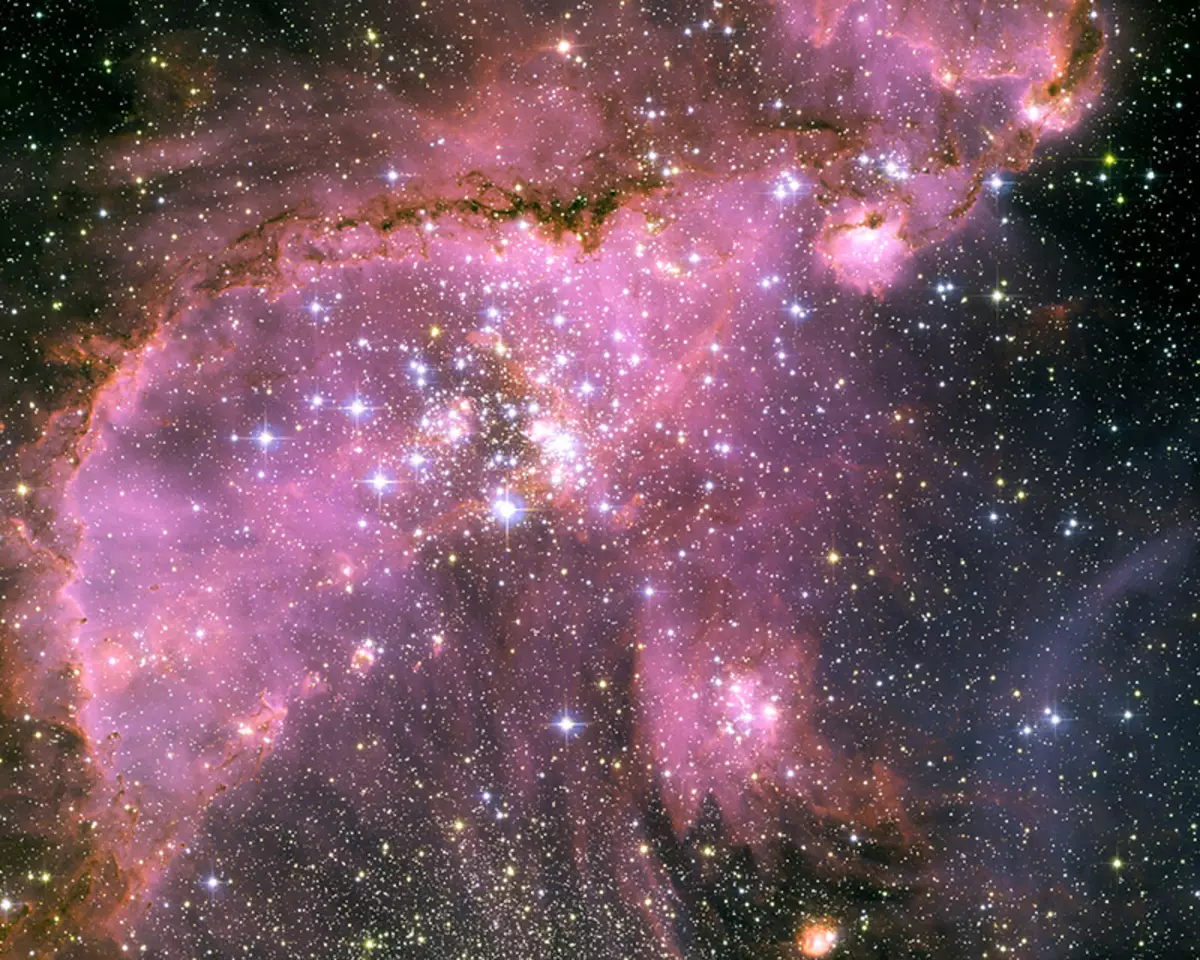 Bu Hubble uzay teleskopu, Samanyolu'nun uydu galaksisi olan küçük Magellanic Cloud'da (SMC), küçük Magellanic Cloud'da (SMC) 210.000 ışıkyılda yer alan uzayda uzayda ayrıntılı yıldız oluşturan bölgeleri görüntüleyin. Bölgenin merkezinde, NGC 346 adlı mükemmel bir yıldız kümesidir. Kemerli bir kemerli, düzensiz filamentlerin dramatik bir yapısı, belirgin bir sırt ile kümeyi çevrelemektedir. Küme NGC 346'daki sıcak yıldızlardan, bu Hubble imajının merkezinde, etrafındaki yoğun alanlara yiyor, toz ve gazın fantezi heykelini yaratıyor. Siluette görülen sırtın karanlık, karmaşık bir şekilde boncuklu kenarı özellikle dramaniktir. Bir oyunda yakalanan rüzgârlar gibi, merkezi kümeye geri dönen birkaç küçük toz globülünü içerir.